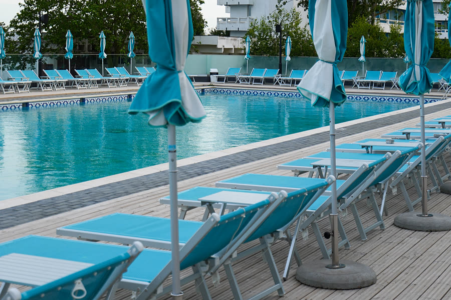 Piscina exterioară a hotelului, cu șezlonguri și vedere la mare
