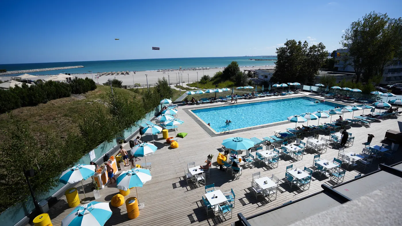Terasa piscinei pregătită pentru Rasova meets Hotel Topaz, văzută de sus, cu plaja și marea