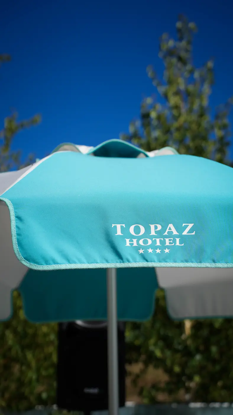 Umbrelă Topaz Hotel, sub cerul de august