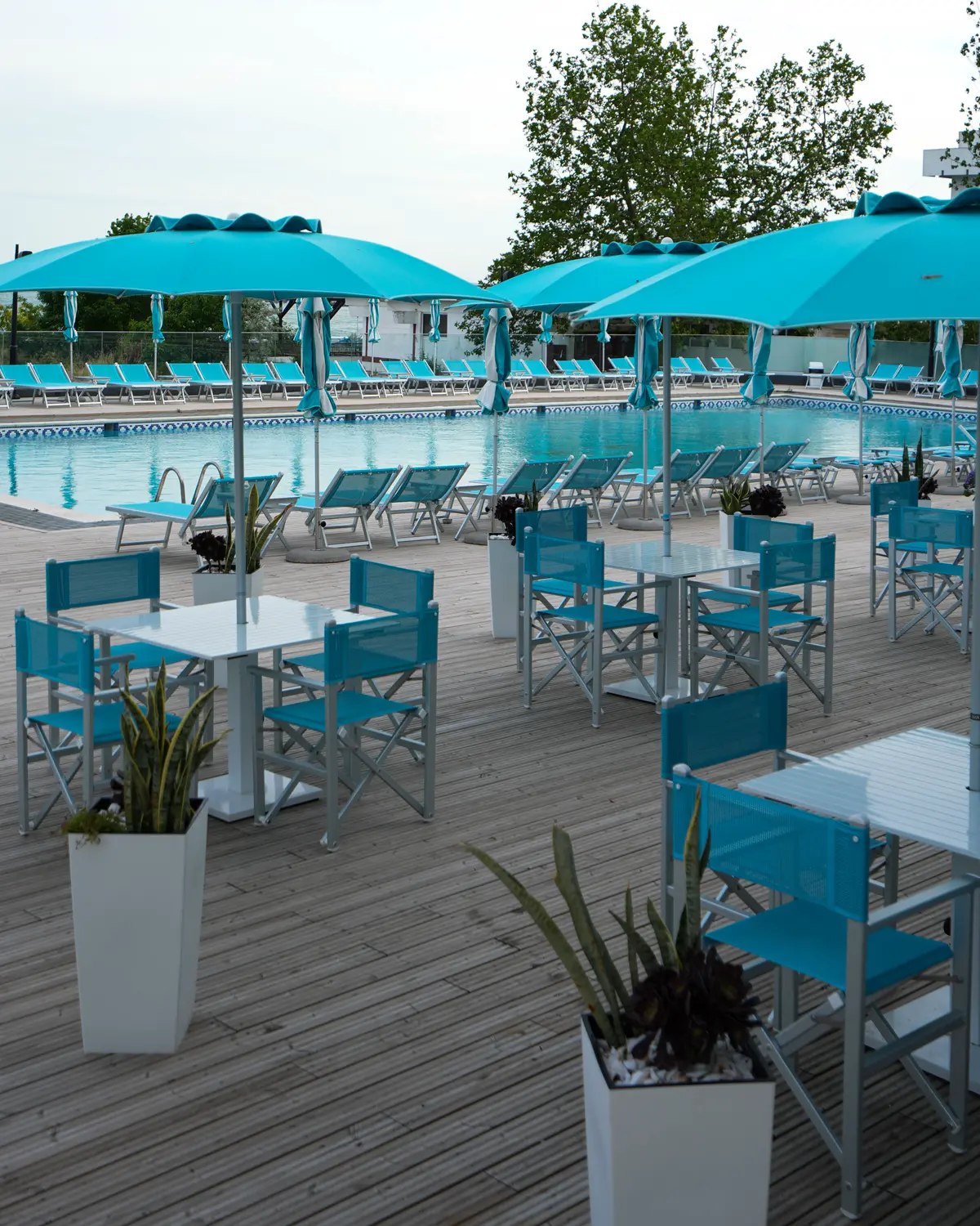 Terasa piscinei, cu mese și umbrele