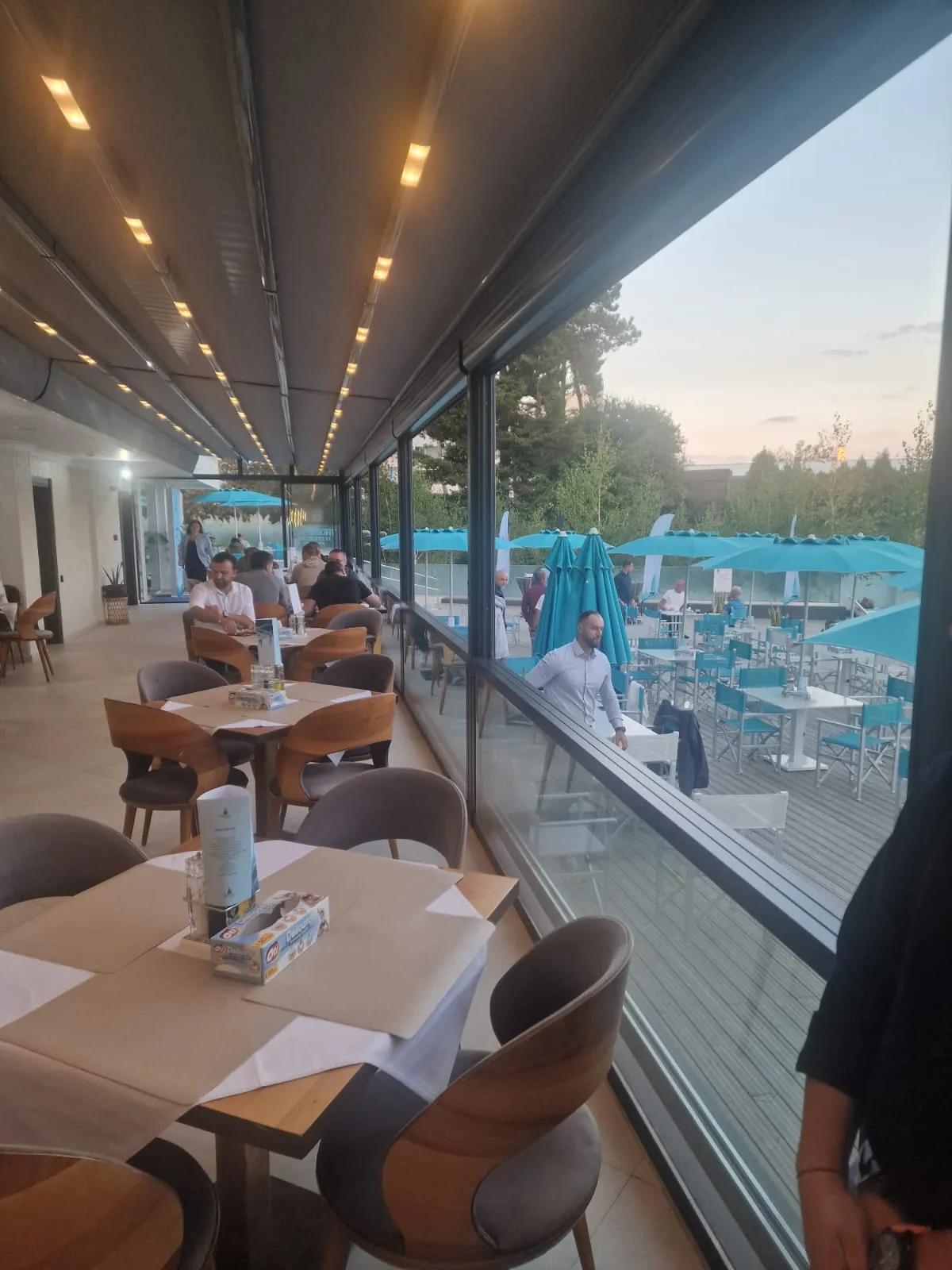 Masă lângă geam, cu piscina dincolo
