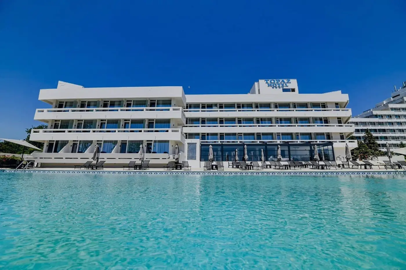 Hotel Topaz văzut de peste piscină, într-o zi senină