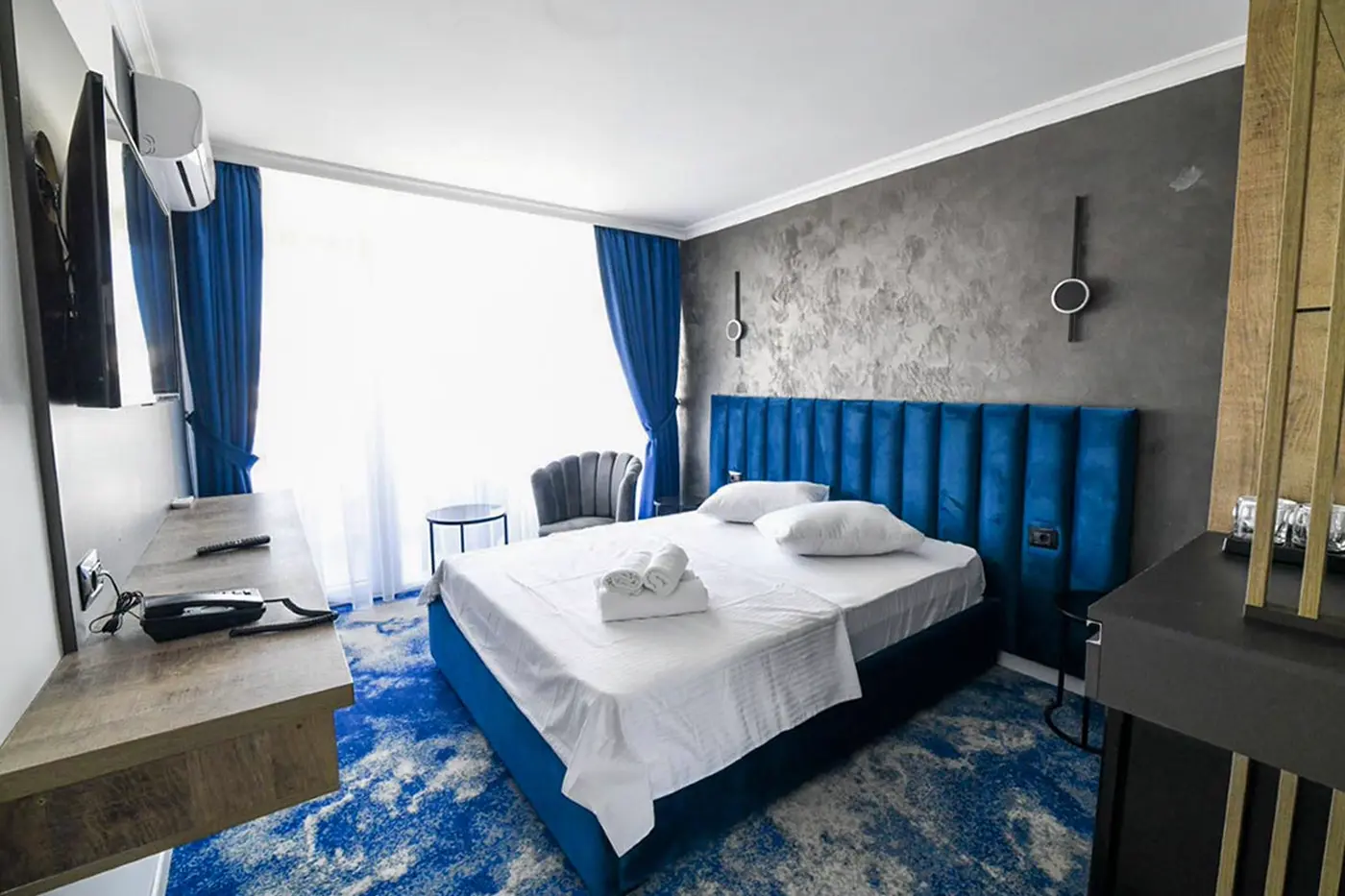 Cameră dublă cu tăblie albastră și draperii până în podea