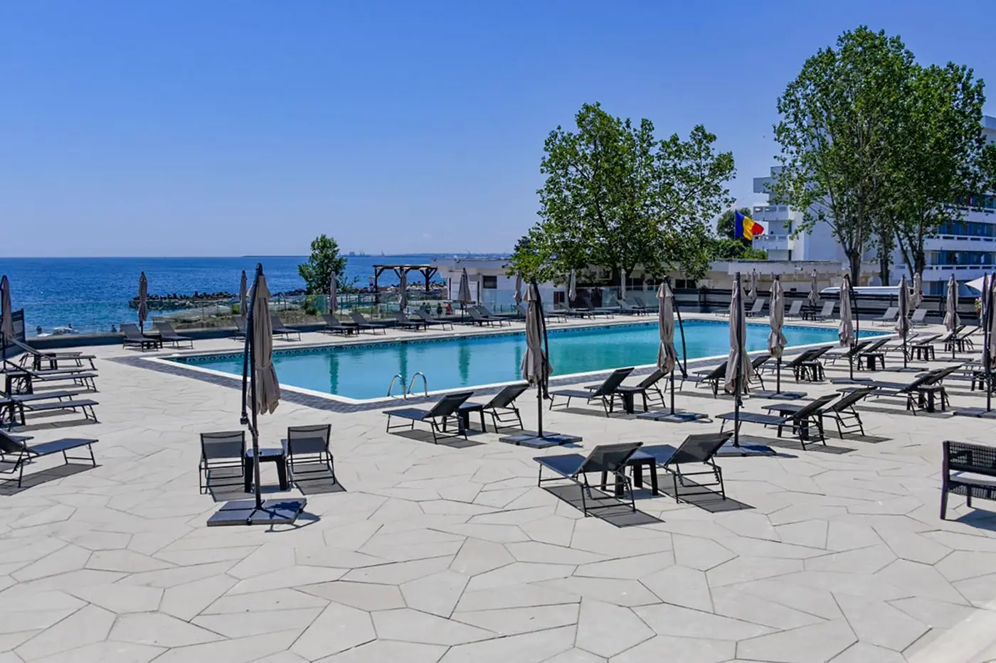 Piscina exterioară și terasa cu șezlonguri