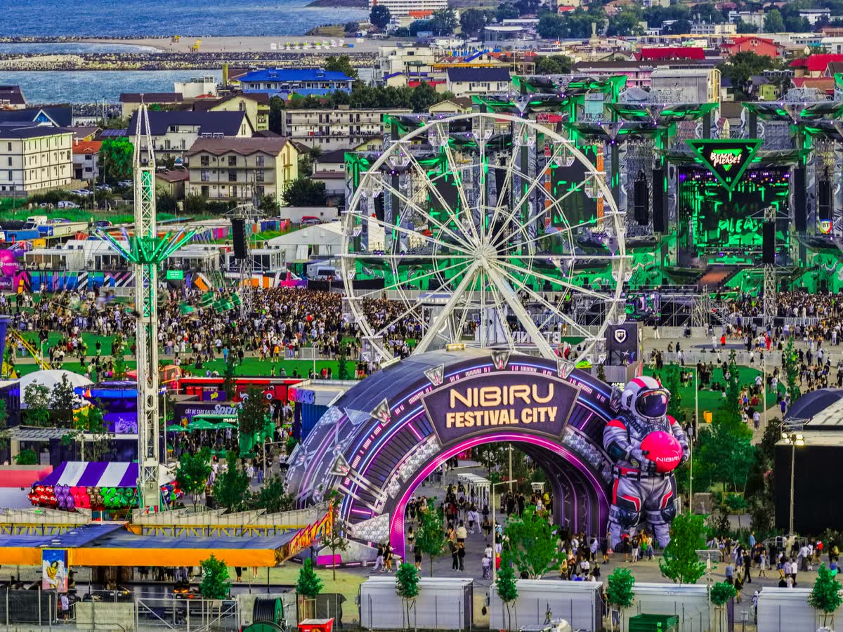 Intrarea în NIBIRU Festival City, ziua, cu roata panoramică
