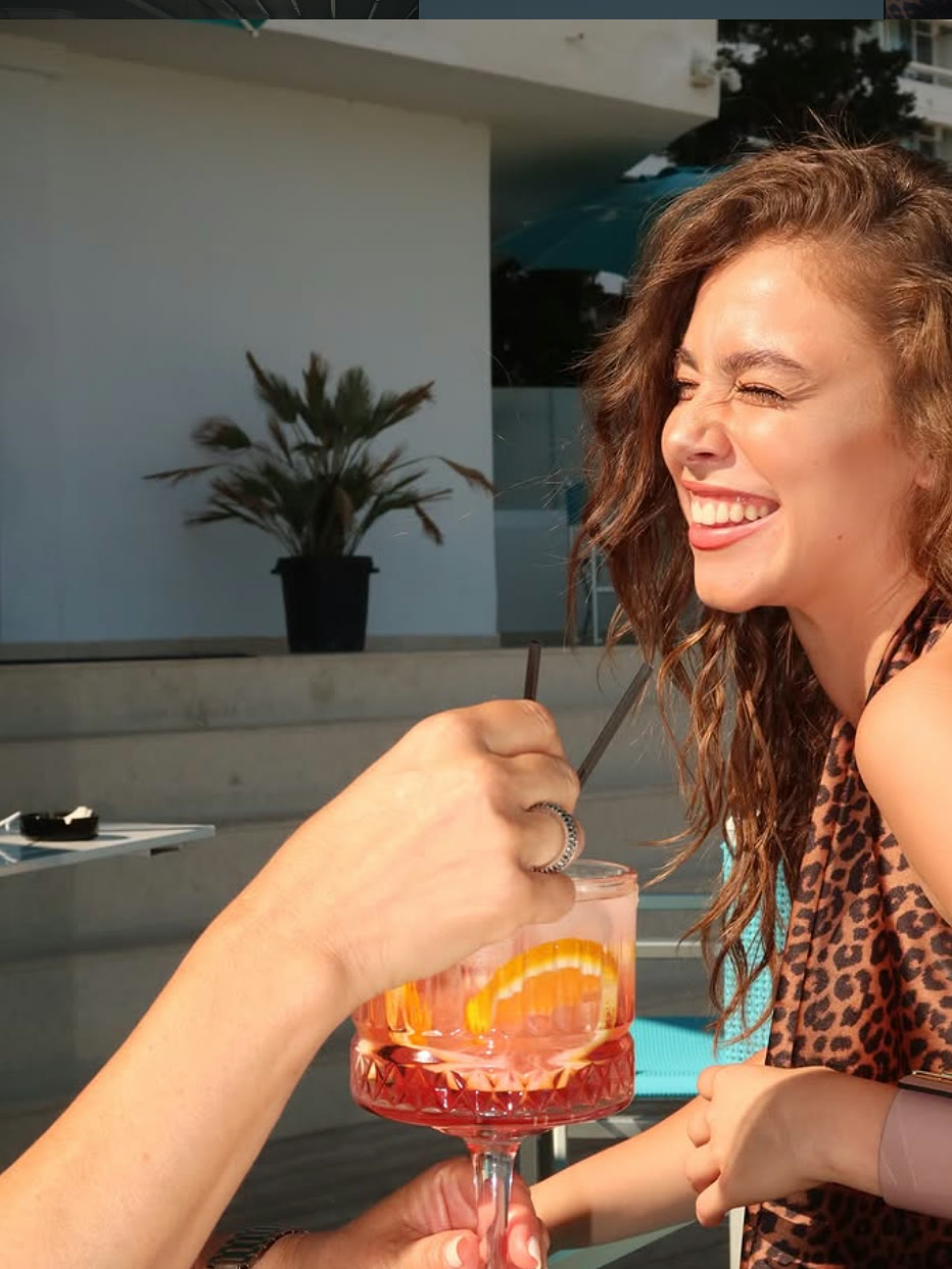 Oaspete la barul de lângă piscină, cu un pahar de aperitiv